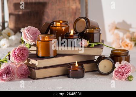 Ein Set verschiedener Duftkerzen in braunen Glasgefäßen. Handgemachte Duftkerze. Sojalkerzen brennen in einem Glas. Aromatherapie und entspannen Sie sich im Spa und zu Hause. Feuer in braunem Glas. Stockfoto