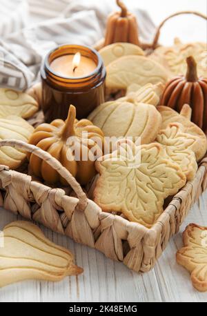 Herbstliches Backen. Kekse in Form von Kürbis und Blättern auf dem Tisch. Gemütliches Herbstkonzept. Stockfoto