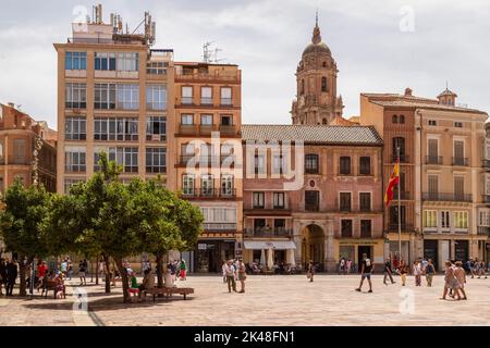 Hauptplatz (Plaza de la Constitucion) in der Stadt Málaga mit dem Turm der Kathedrale im Hintergrund; Spanien. Stockfoto