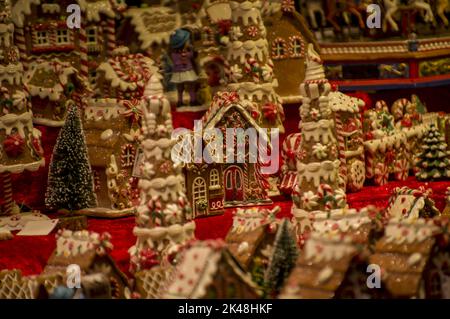 Advent-Basar-Stände mit Glas-, Holz-, Keramik-weihnachts-Souvenirs in einem Geschäft. Nahaufnahme von festlichen Baumdekorationen auf dem nächtlichen Wintermarkt auf der Straße Stockfoto