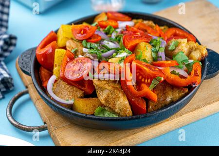 Schweinefleisch Ojakhuri mit Gemüse. Fleisch, Kartoffeln, Zwiebeln, Kräuter, Paprika gekocht und in einer Pfanne serviert. Ein Gericht der georgischen Küche. Fleischgerichte, Mittag- und Abendessen auf dem Tisch Stockfoto