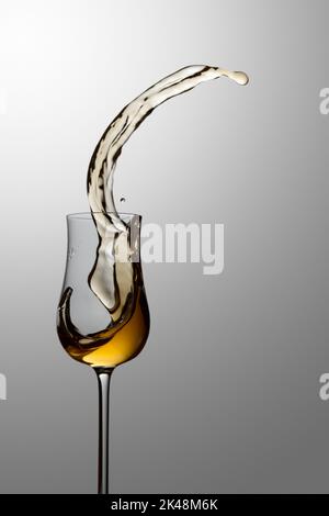 Das Getränk wird aus dem Glas verschüttet. Konzept des Themas Premium-Alkohol. Speicherplatz kopieren. Stockfoto