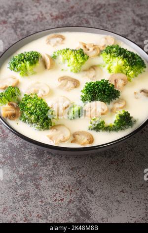 Kitschige Sahnesuppe mit Brokkoli und Pilzen in einer Schüssel auf dem Tisch. Vertikal Stockfoto