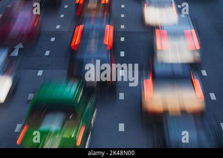 Autos in unscharfer Bewegung auf der städtischen Straße während des abendlichen Staus. City Street in Bangkok, Thailand. Stockfoto