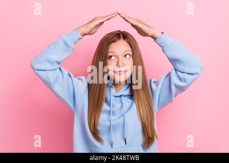 Foto von jungen kleinen ziemlich niedlich schöne Dame positive verträumt halten Hände Schutz Hause Sicherheit suchen leeren Raum isoliert auf rosa Hintergrund Stockfoto