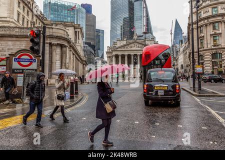 London, Großbritannien. 30. September 2022. Londoners überqueren die Straße vor der Bank of England und der City of London, dem Finanzdistrikt der Hauptstadt, an einem regnerischen Tag, an dem die britische Wirtschaft vom Minibudget der Bundeskanzlerin und des Premierministers erschüttert wird. Kredit: SOPA Images Limited/Alamy Live Nachrichten Stockfoto