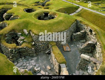 Ansehen W of Iron Age Wheelhouses I & II wurden teilweise über einem früher aiselten Rundhaus in Jarlshof Settlement, Sumburgh, Shetland, Schottland, UK, gebaut. Stockfoto