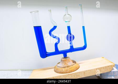 Mehrere verschiedene angeschlossene Röhrchen sind mit einer blauen Flüssigkeit gefüllt, was das Gesetz kommunizierender Gefäße demonstriert. Wird in der Physikklasse verwendet. Stockfoto