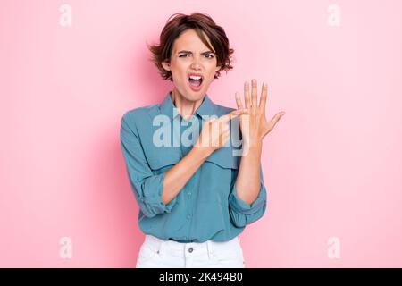 Foto von unzufrieden wütend Mädchen zeigen keine Verlobungsring Finger isoliert auf rosa Hintergrund Stockfoto