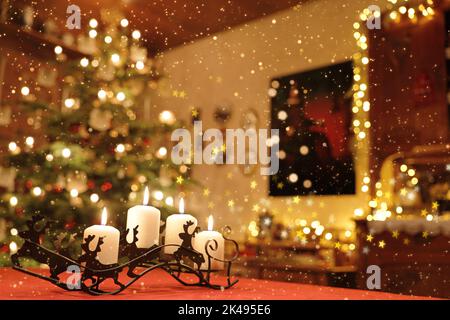 Festlich beleuchtete Weihnachtskammerszene hinter fallendem Schnee Stockfoto