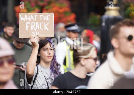 Eine Frau hält ein Schild an einem Protest „Just Stop Oil and Extinction Rebellion“ in Whitehall, im Zentrum von London. Demonstranten der Gruppe starten eine sechswöchige Kampagne zur Besetzung Westminster im Zentrum von London. Bilddatum: Samstag, 1. Oktober 2022. Stockfoto