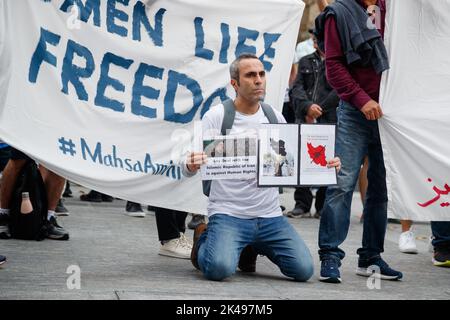 Brisbane, Australien. 01. Oktober 2022. Ein Protestler zeigt Plakate, während er auf dem Boden kniet, während er während einer Kundgebung zur Freiheit im Iran in Brisbane aufruft. Die Demonstranten versammelten sich in Brisbane, um die Freiheit im Iran zu fordern, was unter internationalem Aufschrei und zwei Wochen lang zu Protesten im Land nach dem Tod der 22-jährigen Frau Mahsa Amini kam, die von Mitgliedern der iranischen ‘Moralpolizei' verhaftet und geschlagen wurde, weil sie keinen Hijab trug. Seit Beginn der Proteste im Land vor zwei Wochen wurden Hunderte von Menschen getötet und mehrere Tausend verhaftet. Die iranische Regierung hat einen Versuch unternommen Stockfoto