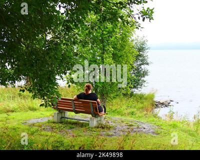 Frau auf einer Holzbank Stockfoto
