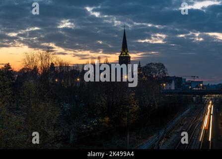 Jette, Region Brüssel-Hauptstadt, Belgien, 11 25 2020 - Blick über die Bahngleise, den Friedhof und die Kirche bei Nacht Stockfoto