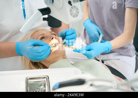 Weibliche Person, die auf dem Zahntrainer mit offenem Mund liegt Stockfoto