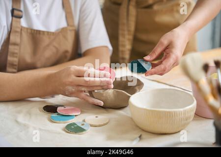 Frauen halten Farbproben für Tonprodukte in den Händen Stockfoto