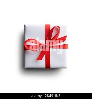 Weiße Geschenkbox mit roter Schleife isoliert auf weißem Hintergrund. Kreatives Postkarten-Design für Weihnachten und Valentinstag Stockfoto