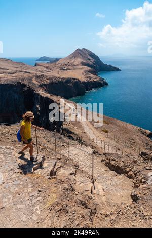 Eine vertikale Aufnahme einer jungen Frau in Sao Lourenco auf der Treppe des Trekkingweges auf Madeira Stockfoto