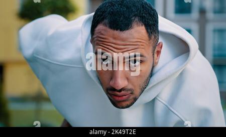 Müde, latino-birassische Sportler, der nach hartem Training stoppt, Ende des Workouts Atmung starker Druck in der Brustruhe Stockfoto