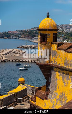 Eine vertikale Aufnahme des alten gelben Wachturms am Strand von Forte de Sao Tiago in Funchal, Madeira Stockfoto