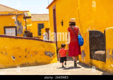 Eine Mutter und ein Sohn in der Nähe des alten Wachturms in Forte de Sao Tiago, Funchal, Madeira Stockfoto