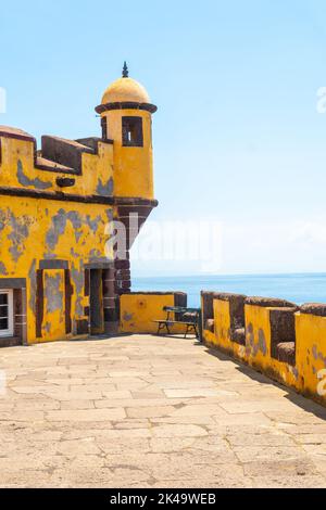 Eine vertikale Aufnahme des alten gelben Wachturms am Strand von Forte de Sao Tiago in Funchal, Madeira Stockfoto