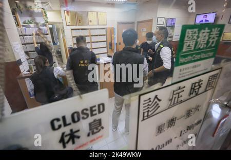 Polizeibeamte untersuchen in der Klinik von Doktor Wong Ping-leung auf dem hing Wah Plaza, Chai Wan. Dr. Wong von Chai Wan, Dr. Charlie Yan kam-Sun von Yuen Long und Dr. Amy Lam Ding-yee von Tin Shui Wai wurden verhaftet, weil sie illegal Covid-19-Impfgenehmigungen ausgestellt hatten. 22SEP22 Jelly Tse/SCMP Stockfoto