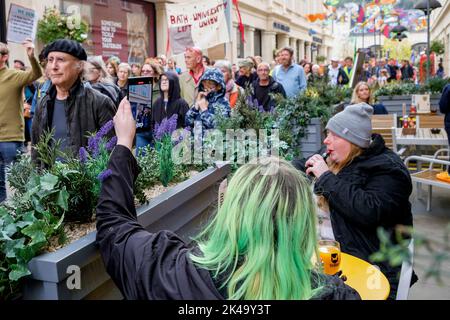 Bath, Großbritannien. 1. Oktober 2022. Shopper in Bath, die einen Drink genießen, sehen zu, wie Demonstranten durch das Stadtzentrum marschieren. Die „genug ist genug“-Kosten für die Protestkundgebung und den marsch wurden von Bath Trades Union und Bath Campaigns Network organisiert. Quelle: Lynchpics/Alamy Live News Stockfoto