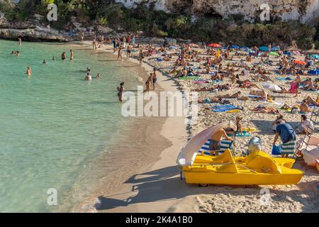 Cala Llombards, Spanien; september 23 2022: Blick auf den mediterranen Strand von Cala Llombards, mit Touristen, die sich sonnen und am Strand schwimmen Stockfoto