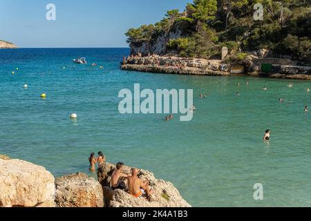 Cala Llombards, Spanien; september 23 2022: Blick auf den mediterranen Strand von Cala Llombards, mit Touristen, die sich sonnen und am Strand schwimmen Stockfoto