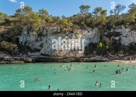 Cala Llombards, Spanien; september 23 2022: Blick auf den mediterranen Strand von Cala Llombards, mit Touristen, die sich sonnen und am Strand schwimmen Stockfoto