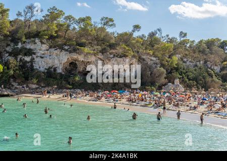 Cala Llombards, Spanien; september 23 2022: Blick auf den mediterranen Strand von Cala Llombards, mit Touristen, die sich sonnen und am Strand schwimmen Stockfoto