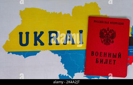 25. September 2022, Moskau, Russland. Militärticket eines Reservesoldaten der Russischen Föderation auf dem Hintergrund einer Karte der Ukraine Stockfoto