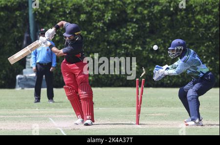 Kinchit Shah (L) des Hong Kong Cricket Club wird von dem Bowler des United Services Recreation Club Mohammad Ghazanfar gewirtet, da Wicket-Torwart Umar Muhammad (R) in Aktion ein Spiel während der Hong Kong MenHH Premier League, gesponsert von Gencor Pacific Limited, im Hong Kong Cricket Club in Tai Tam reagiert. 25SEP22 SCMP/Edmond so Stockfoto