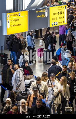 2022-10-01 18:07:57 EINDHOVEN - Reisende am Flughafen Eindhoven stehen aufgrund einer technischen Störung im Gepäckabfertigungssystem länger in der Schlange. Anfang dieses Monats war auch das Gepäckabfertigungssystem des Flughafens Eindhoven defekt und die Passagiere wurden durch den nicht-Check-in gestört. ANP ROB ENGELAAR niederlande aus - belgien aus Stockfoto