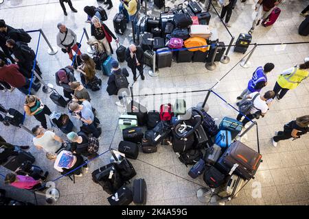 2022-10-01 18:05:24 EINDHOVEN - Reisende am Flughafen Eindhoven stehen aufgrund einer technischen Störung im Gepäckabfertigungssystem länger in der Schlange. Anfang dieses Monats war auch das Gepäckabfertigungssystem des Flughafens Eindhoven defekt und die Passagiere wurden durch den nicht-Check-in gestört. ANP ROB ENGELAAR niederlande aus - belgien aus Stockfoto