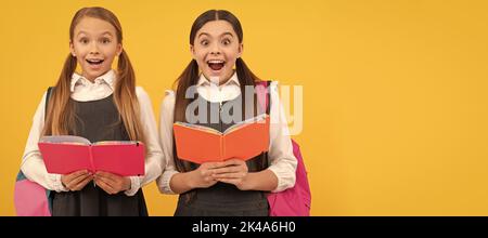 Schulmädchen Freunde. Überraschte Kinder in formellen Uniformen lesen Schulbücher gelben Hintergrund, Bibliothek. Banner der Schülerin. Schülerin Stockfoto