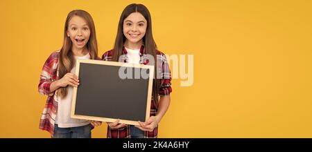 Schule Mädchen Freunde. Glückliche Kinder in lässig kariert halten Schule Tafel für Kopie Raum. Porträt einer Schülerin, Studio-Banner-Header Stockfoto