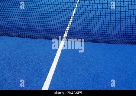 Blick auf das Netz und die Mittellinie eines blauen Paddle-Tennisplatzes. Stockfoto