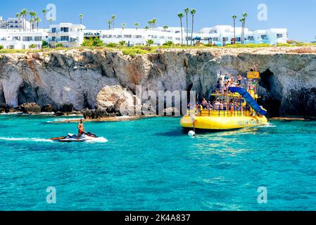 Ayia Napa, Zypern - 28. Juli 2019: Vergnügungsboote voller Touristen im Mittelmeer Stockfoto