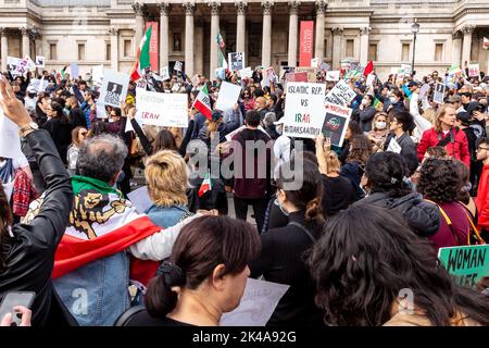 Demonstranten halten iranische Flaggen (alte persische Version) und Plakate, Und chanten regimefeindliche Parolen während eines Solidaritätsproteste mit iranischen Frauen, als Teil der geplanten weltweiten Proteste gegen das Regime der Islamischen Republik Iran nach dem Tod von Mahsa Amini am Trafalgar Square, London, Großbritannien, am 1. Oktober 2022. Der Tod von Mahsa Amini, 22, aus Kurdistan, die von der Moralpolizei in Teheran verhaftet wurde, weil sie ihren Hijab nicht richtig trug, hat eine Welle von Protesten im Iran und in der ganzen Welt ausgelöst. Amini wurde in eine Haftanstalt gebracht, wo sie zusammenbrach und später im Krankenhaus starb. Die r Stockfoto