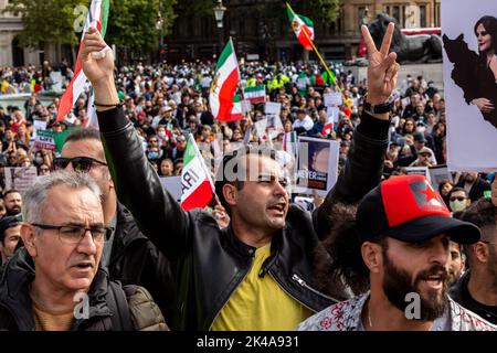 Demonstranten halten iranische Flaggen (alte persische Version) und Plakate, Und chanten regimefeindliche Parolen während eines Solidaritätsproteste mit iranischen Frauen, als Teil der geplanten weltweiten Proteste gegen das Regime der Islamischen Republik Iran nach dem Tod von Mahsa Amini am Trafalgar Square, London, Großbritannien, am 1. Oktober 2022. Der Tod von Mahsa Amini, 22, aus Kurdistan, die von der Moralpolizei in Teheran verhaftet wurde, weil sie ihren Hijab nicht richtig trug, hat eine Welle von Protesten im Iran und in der ganzen Welt ausgelöst. Amini wurde in eine Haftanstalt gebracht, wo sie zusammenbrach und später im Krankenhaus starb. Die r Stockfoto