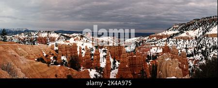 Bryce Canyon Panorama im bewölkten Wintertag mit orangen Felsen und Schnee Stockfoto