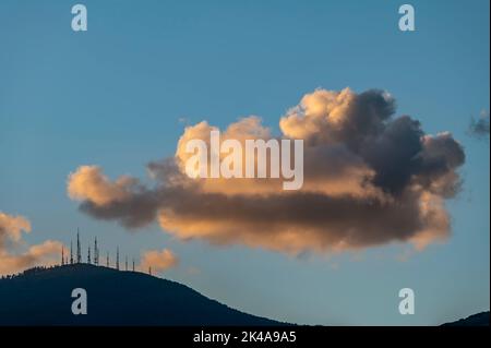 Die Spitze des Monte Serra in der Provinz Pisa, Italien, mit den Antennen gegen den Sonnenuntergang Himmel Stockfoto