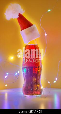 Rom Italien. September - 06. 2020. Coca-Cola-Glaskachelchen in einem Weihnachtshut auf gelbem Hintergrund Stockfoto