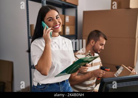 Männer und Frauen, die im Geschäft mit dem Smartphone sprechen und das Etikett mit einem Barcode-Lesegerät scannen Stockfoto