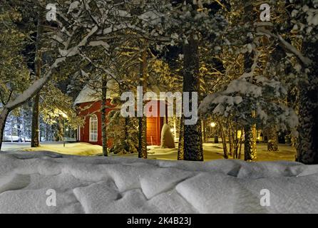 Alte Kirche in Jokkmokk im Winter, rotes Holzgebäude, schneebedeckte Bäume, Lappland, Schweden Stockfoto