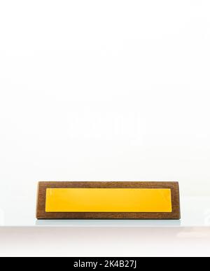 Gelbe Büroplatte aus Holz auf weißem Hintergrund mit Titel leer Kopie einfügen Raum. Gelbe Leerplatzplatte im Büro isoliert in Whi Stockfoto
