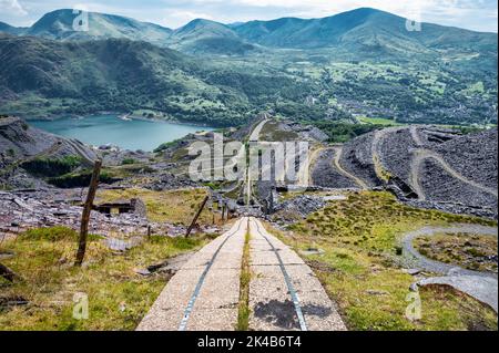 Dinorwic, Großbritannien, 12. Juli 2022: Stillgelegte, abfallende Abbaustrecke im verlassenen Schiefersteinbruch bei Dinorwic in den Bergen von Nordwales Stockfoto