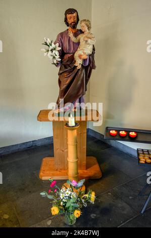 St. Joseph mit Jesuskind, Blumenschmuck und Kerzen anbieten, moderne Kirche, St. Michael, Kempten, Allgäu, Bayern, Deutschland Stockfoto